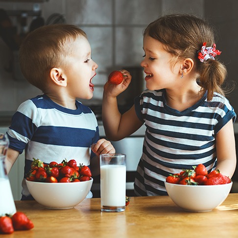 siblings eating fruit
